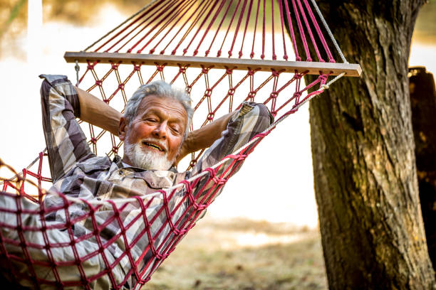 istock Caucasian Senior man lying on hammock in a pine forest. Outdoors relaxation. 1326287698