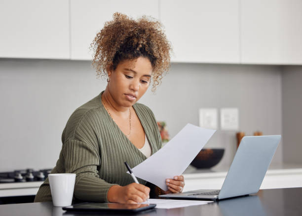 Shot of a woman filling in some paperwork at home Life can wait, get distracted! claim form stock pictures, royalty-free photos & images