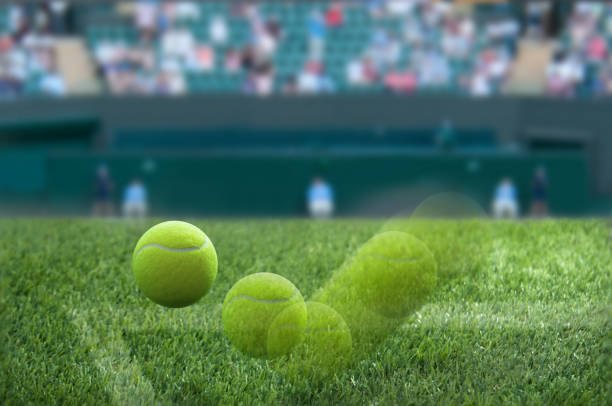 Tennis ball bouncing on a grass court Closeup motion shot of wimbledon tennis ball bouncing on grass court surface wimbledon stock pictures, royalty-free photos & images