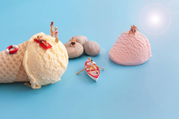 Ice cream beach scene concept Miniature sunbathers on ice cream scoops figurine stock pictures, royalty-free photos & images
