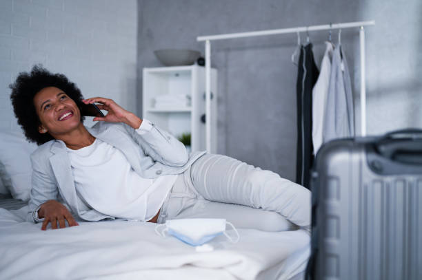 istock Young black business women just arrived at the hotel taking a rest from a trip, using a smart phone 1326290723