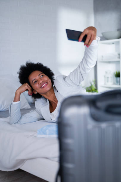 istock Young black business women just arrived at the hotel taking a rest from a trip, using a smart phone 1326291488