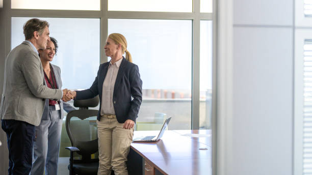 istock Female executive shaking hands with business partner in an office 1326297228