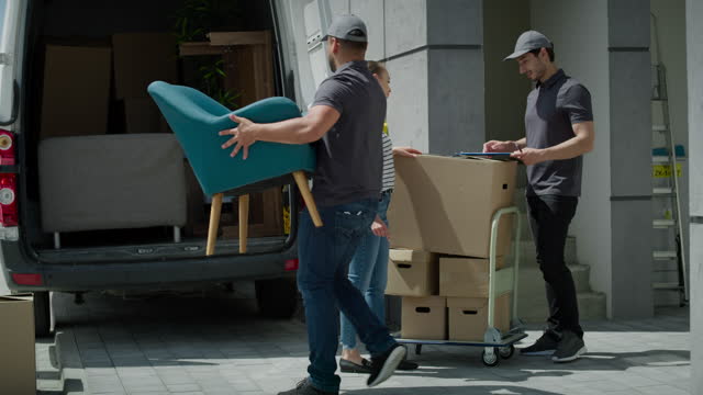 Video of delivery men loading customer packages onto truck. Shot with RED helium camera in 8K.
