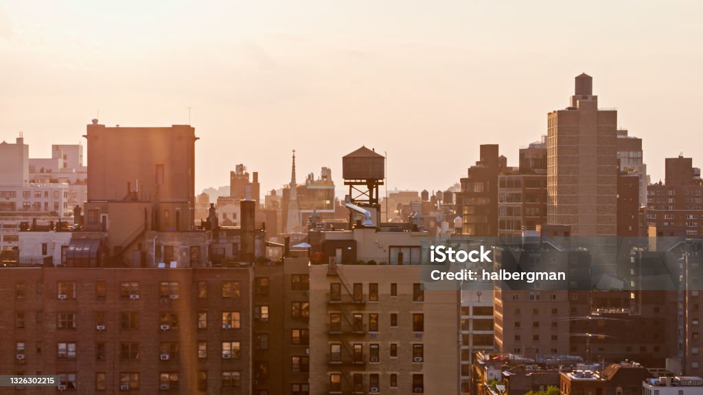 Drone Shot of East Side of Manhattan at Sunset Aerial establishing shot of Manhattan, taken from over the East Village, on a sunny evening in summer. East Village Stock Photo