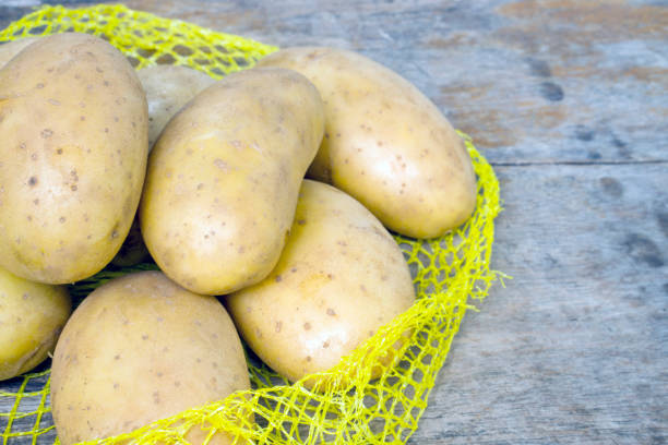 istock Raw potatoes on the net for cooking 1326302959