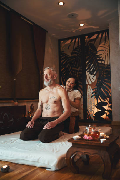 asian woman doing thai massage for man - tattoo japanese culture women asian ethnicity imagens e fotografias de stock