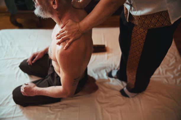 kobieta robi masaż dla męskich ramion w centrum spa - tattoo japanese culture women asian ethnicity zdjęcia i obrazy z banku zdjęć