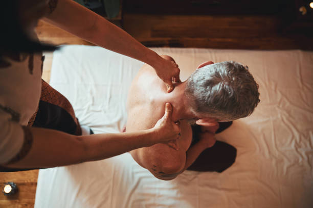 grizzled man being treated in exotic spa centre - tattoo japanese culture women asian ethnicity imagens e fotografias de stock