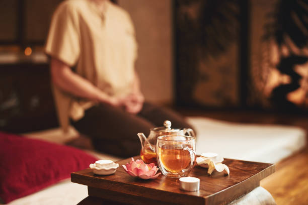 homem fazendo meditação durante cerimônia de chá dentro de casa - massaging relaxation indoors traditional culture - fotografias e filmes do acervo