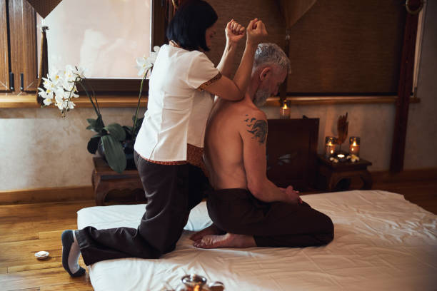 istock Asian manual therapist treating lean mature man 1326305125