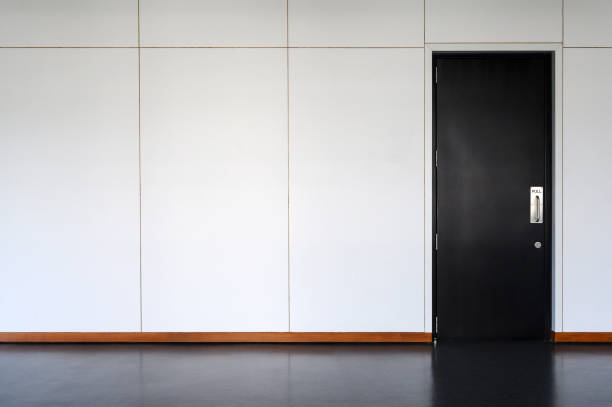 istock modern black Wooden door Closed Shut with metallic handle on white wall. Empty room interior. Free space for display or montage products. 1326306339
