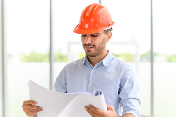istock Portrait of construction engineer manager workers in orange hardhat and looking layout plan. posing standing in office. copy space for text 1326306406