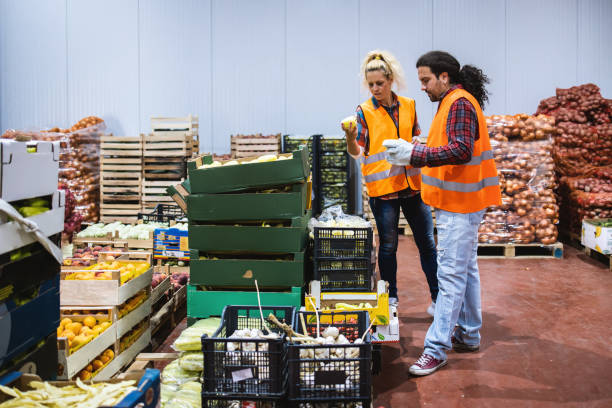 istock Two people a young man and a girl,work in a fruit and vegetable warehouse. 1326306941