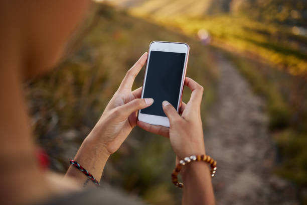 istock Cropped shot of a woman using her cellphone while out on a hike 1326307920