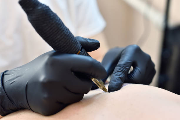 istock Woman tattooist makes a tattoo on hand. 1326307927