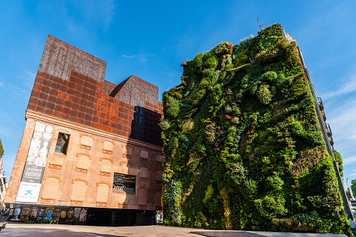 Madrid, Spain - May 8, 2021: Outdoors view of CaixaForum Madrid, Spain. It is a museum and cultural center in Paseo del Prado sponsored by La Caixa Bank, designed by Herzog and de Meuron