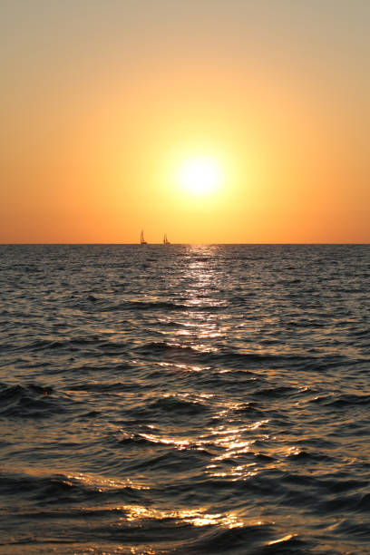 морской закат рябь волна узор яхта силуэт золотой час солнечный свет лето абстрактное отражение светящийся синий синий золотой оранжевый � - sunset to night стоковые фото и изображения