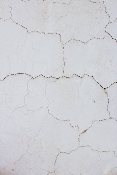 istock Close up of textured cracked vertical white old wall background 1326316067