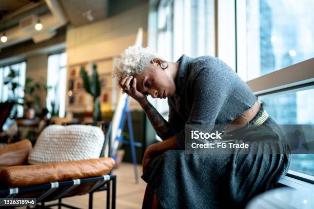 Worried Businesswoman Sitting By The Window At The Office Stock Photo - Download Image Now