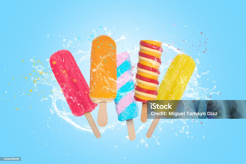 Colorful popsicles ice cream on blue background with splash. Flavored Ice Stock Photo
