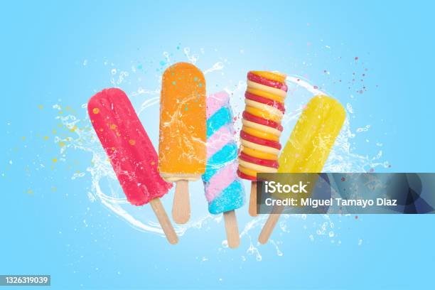 Colorful Popsicles Ice Cream On Blue Background With Splash Stock Photo - Download Image Now