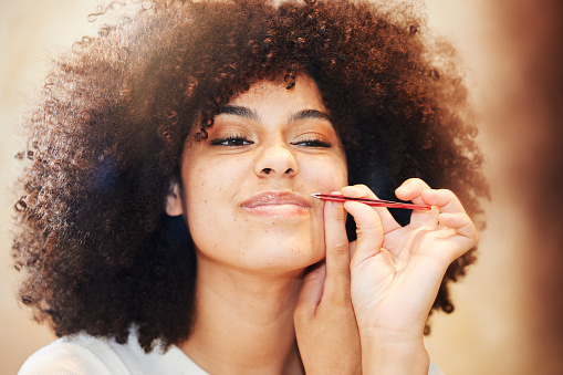 Foto de una hermosa joven usando una pinza para arrancar el cabello en su labio superior photo
