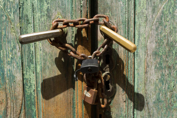 istock Close-up on old rusty metal lock with a chain on the door. 1326319266