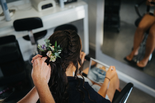 Hairdresser places flower ornaments in her hair