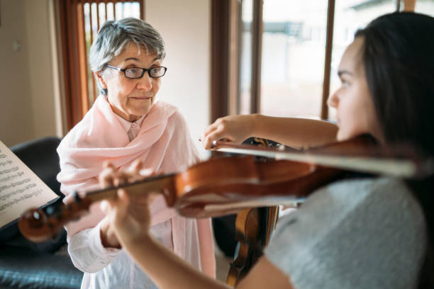istock Senior violin teacher explaining to her student how to play music 1326321794