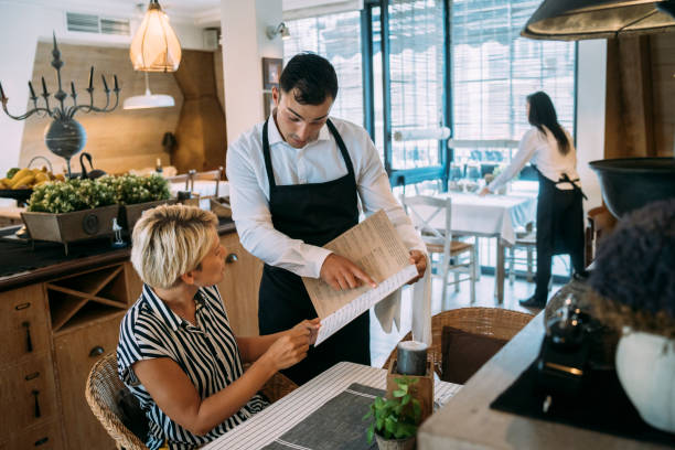 istock Waiter ordering a menu to a customer in a restaurant 1326322461