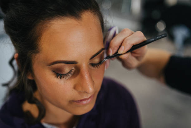 Makeup artist paints her eyelids with eyeshadow
