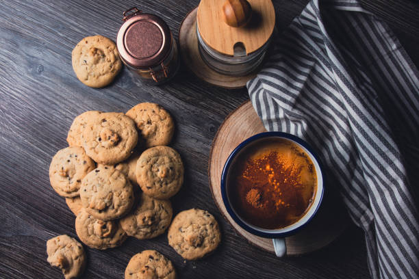 Cup of chicory coffee and chocolate chip cookies. Concept for a sweet snack, afternoon sweet dessert. Rustic wooden background.