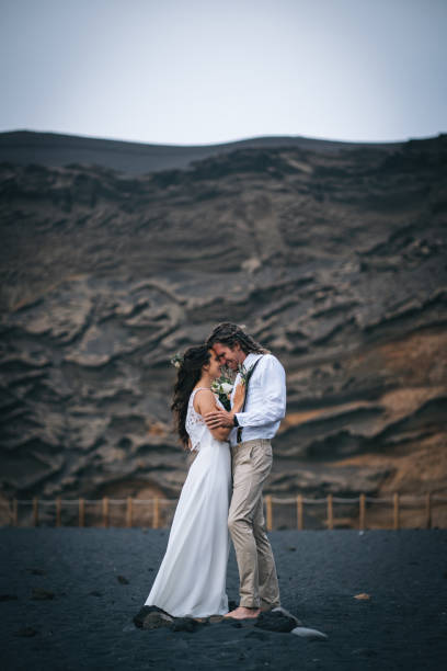 istock Newlyweds dance on rocky beach after wedding 1326324192