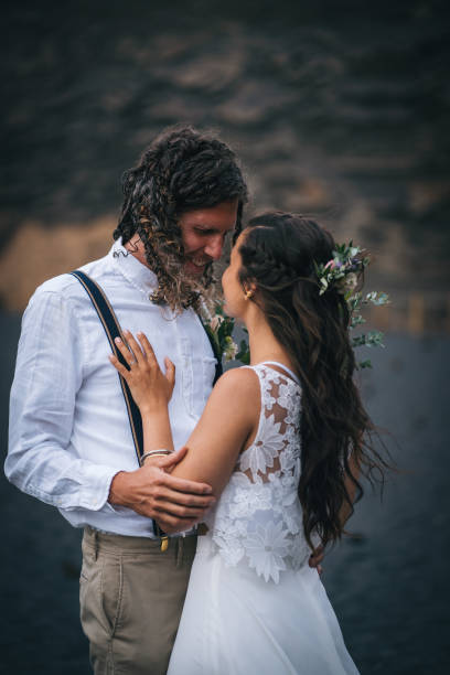 istock Newlyweds dance on rocky beach after wedding 1326324217