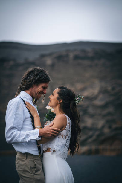 istock Newlyweds dance on rocky beach after wedding 1326324232