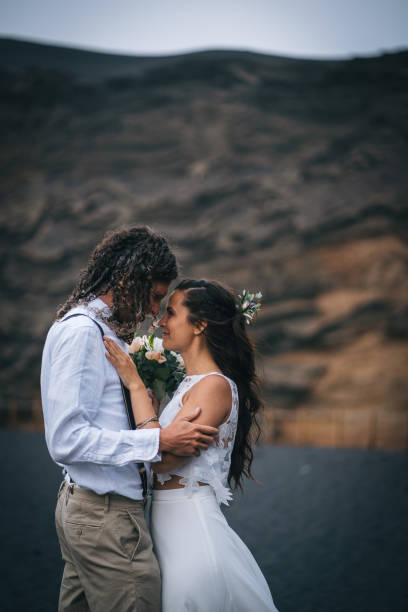 istock Newlyweds dance on rocky beach after wedding 1326324422