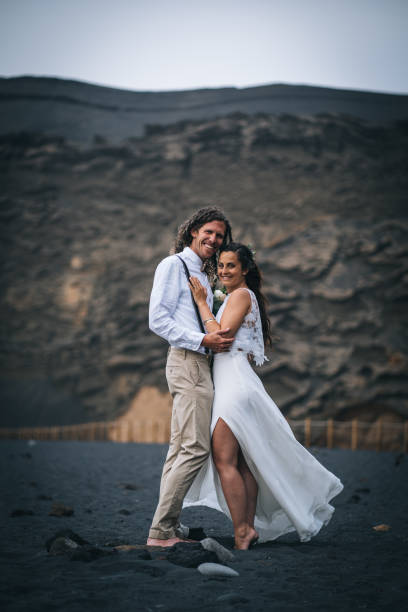 istock Newlyweds relax after wedding on rocky beach 1326324424
