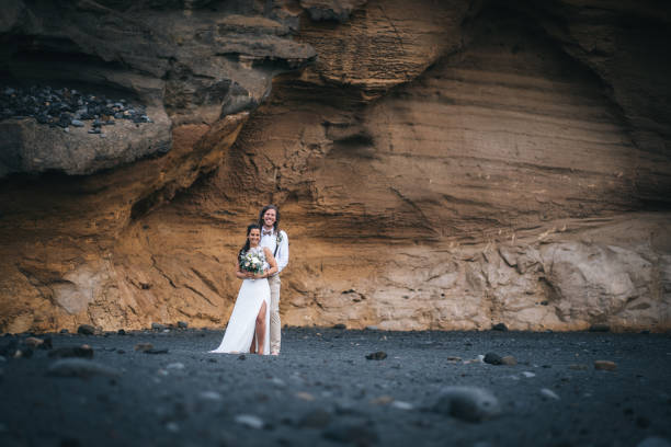 istock Newlyweds relax after wedding on rocky beach 1326324978