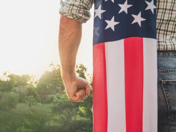 istock Handsome man holding US flag in his hands 1326325028