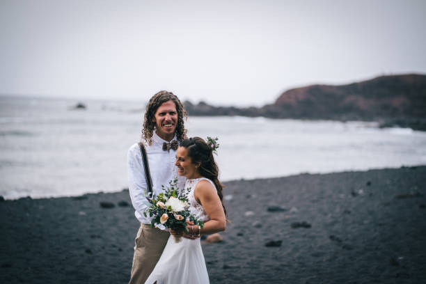 istock Newlyweds relax after wedding on rocky beach 1326325129