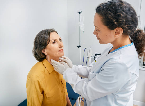Doctor palpates of fat mature woman's neck for diagnostics of thyroid diseases and hypothyroidism at medical clinic. Thyroid treatment Doctor palpates of fat mature woman's neck for diagnostics of thyroid diseases and hypothyroidism at medical clinic. Thyroid treatment thyroid gland stock pictures, royalty-free photos & images