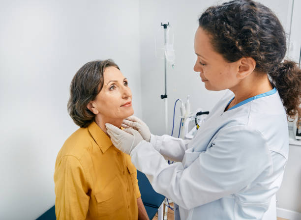 médico palpates de gordura maduro pescoço de mulher para diagnóstico de doenças da tireoide e hipotireoidismo na clínica médica. tratamento da tireoide - human immune system - fotografias e filmes do acervo