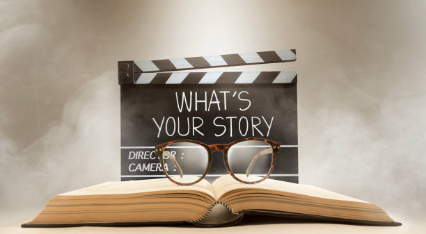 qual è la tua storia, titolo di testo sulla lavagna del film, e occhiali in cima al vecchio libro - copione foto e immagini stock