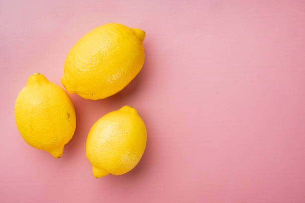 istock Yellow ripe lemon, on pink textured summer background, with copy space for text 1326331784
