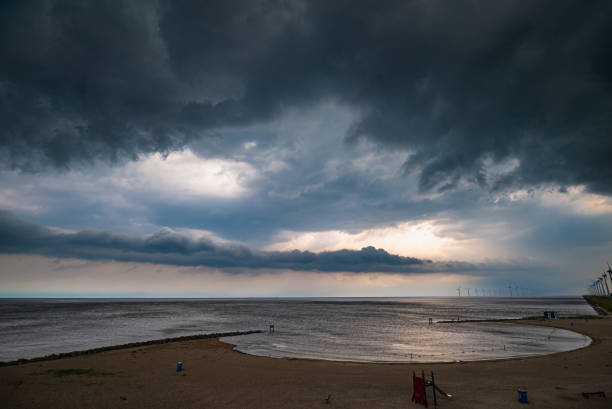 dark, threatening storm clouds over a lake - cumulonimbus imagens e fotografias de stock