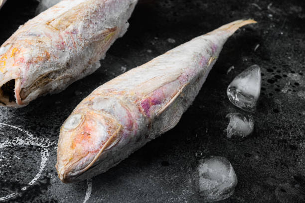 istock Frozen red mullet or barabulka raw fish, on black dark stone table background 1326335406