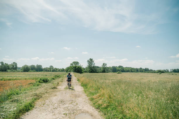 istock Young man rides bicycle through Tuscany countryside 1326339448