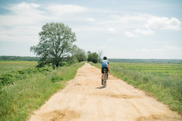istock Young man rides bicycle through Tuscany countryside 1326339552