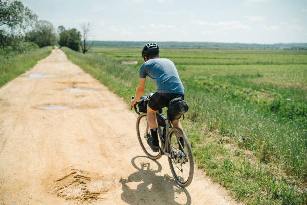 istock Young man rides bicycle through Tuscany countryside 1326339554